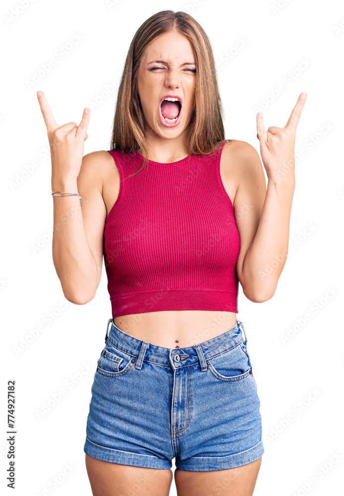 Young beautiful blonde woman wearing elegant summer shirt shouting with crazy expression doing rock symbol with hands up. music star. heavy concept. Young beautiful blonde woman wearing elegant summer shirt shouting with crazy expression doing rock symbol with hands up. music star. heavy concept.