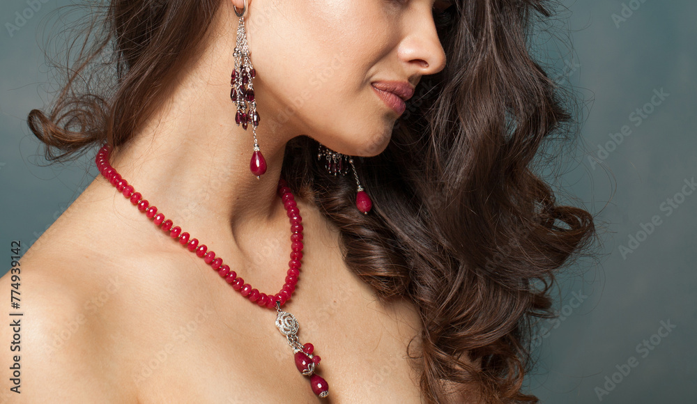 Beautiful jewelry model closeup. Necklace and earring with red garnet stones