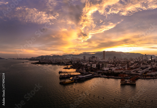 Penang, Malaysia: Dramatic aerial panoramic view of the sunset over Georgetown historic colonial city center with ferry terminal and harbor in Malaysia.