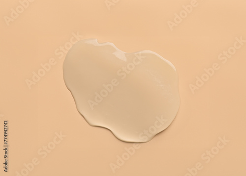 water drops of transparent gel serum on beige background photo