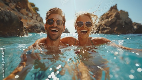 A young couple and a beautiful young woman wearing swimsuits play in the sea or a natural swimming pool showing couples having fun on vacation. photo