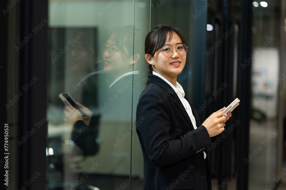 Portrait of young Asian woman with smile. happy asian businesswoman using mobile phone. Modern office workplace Portrait of young Asian woman with smile. happy asian businesswoman using mobile phone. Modern office workplace