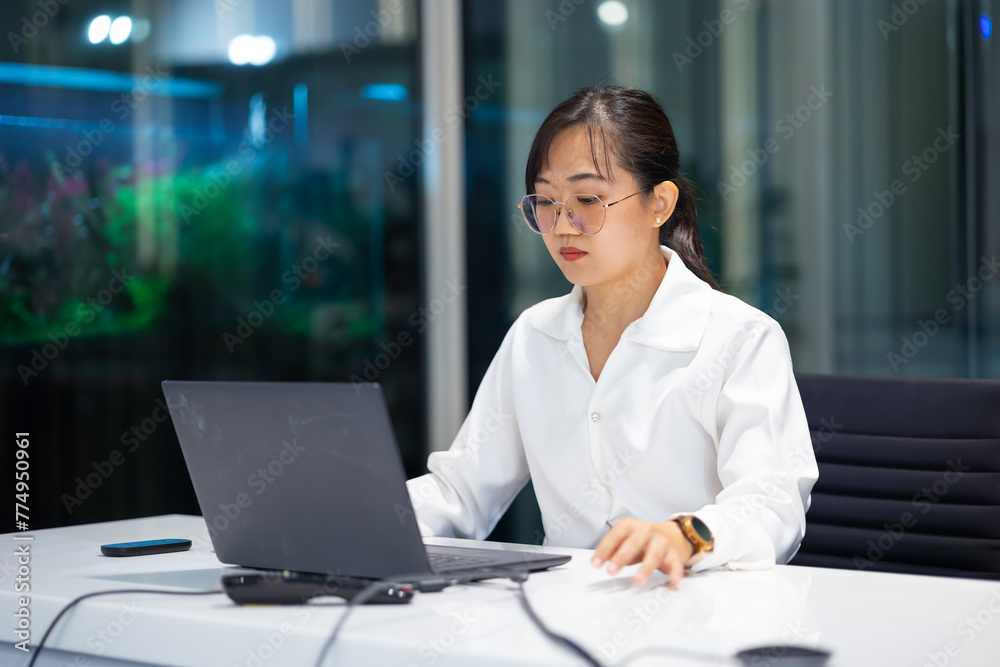 working woman - business woman busy working on laptop computer at moder office workspace. Attractive beautiful Asian business woman working in home office.