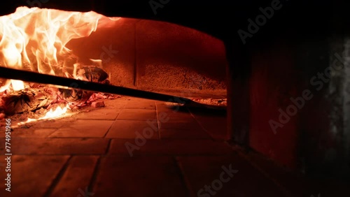 Man Is Baking Neapolitan Pizza In The Wood Fired Oven photo