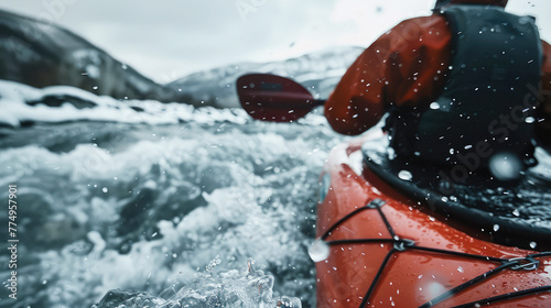 extreme kayaker floats down a fast, stormy mountain river in winter, close-up