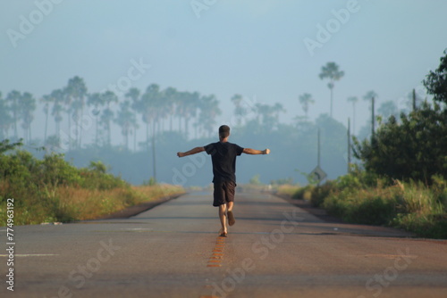 homem caminhando em rodovia em Calçoene, Amapá, em amanhecer com neblina  photo
