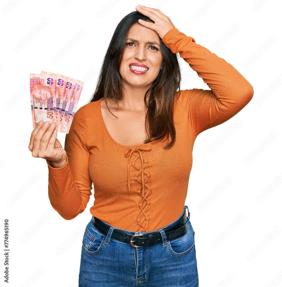 Beautiful hispanic woman holding south african 50 rand banknotes stressed and frustrated with hand on head, surprised and angry face Beautiful hispanic woman holding south african 50 rand banknotes stressed and frustrated with hand on head, surprised and angry face