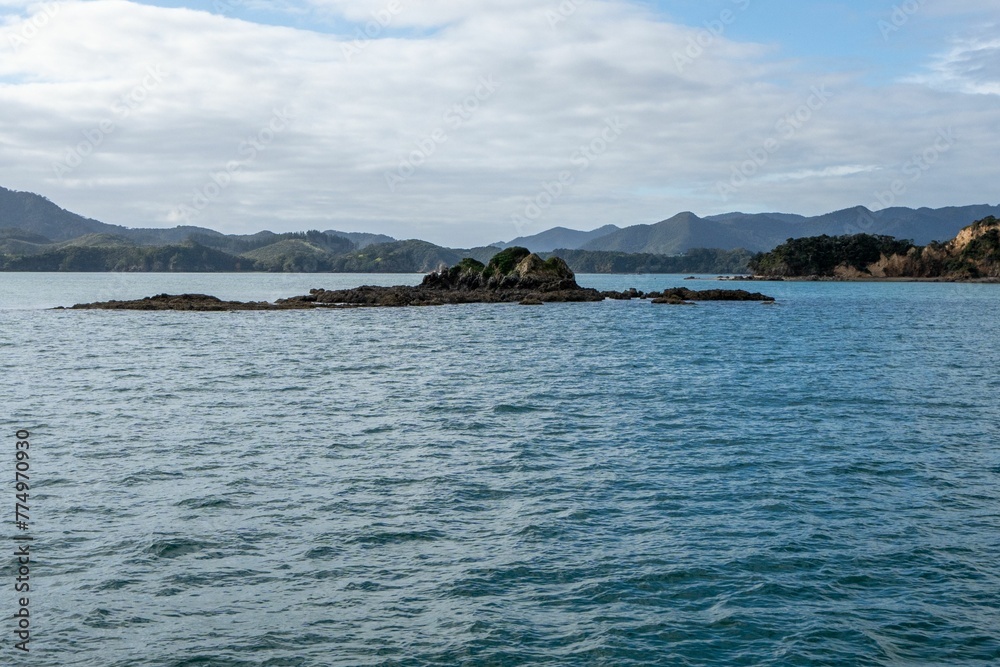 Sunlit seascape view with cloudy sky background, Bay of islands