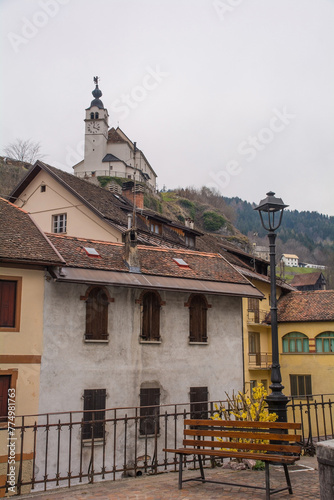 Old residential buildings in the mountain village of Rigolato in Carnia, Friuli-Venezia Giulia,  North East Italy. The Parish Church of Saints Philip and James is in the background photo