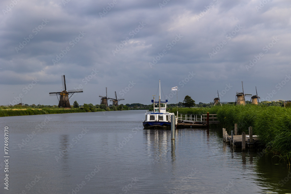 Kinderdijk, South Holland, Netherlands - July, 2, 2023: Beautiful wooden windmills at sunset in the Dutch village of Kinderdijk. Windmills run on the wind. The beautiful Dutch canals