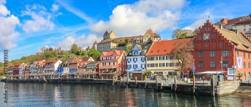 Picturesque panorama of the lakeshore of the town Meersburg at Lake Constance with the building Gredhaus and the medieval castle Burg Meersburg on a rocky outcropping in the background.