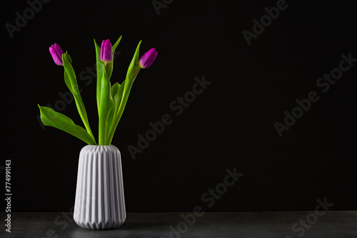 boquet of tulip on a black background standing in a vase