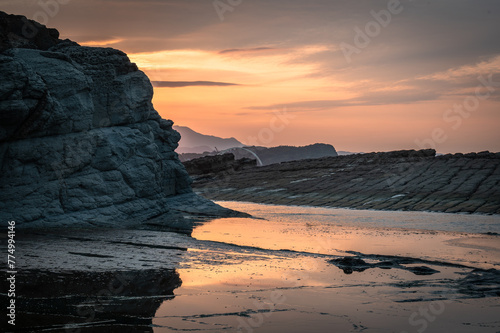Fototapeta Naklejka Na Ścianę i Meble -  Sunset time at the coastline of Badouzi, sunlight shines on the water with gorgeous rocks by the side, in Keelung city, Taiwan.