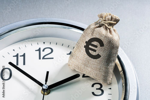 euro, time, business, time is money and finance concept. the hand of the clock points to money bag with euro sign