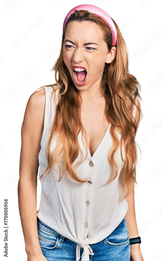 Young caucasian woman wearing casual style with sleeveless shirt angry and mad screaming frustrated and furious, shouting with anger. rage and aggressive concept. Young caucasian woman wearing casual style with sleeveless shirt angry and mad screaming frustrated and furious, shouting with anger. rage and aggressive concept.