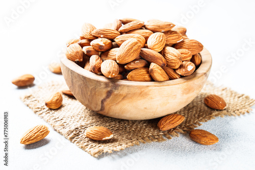 Almond nuts in wooden bowl at white background. photo