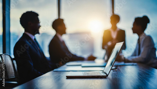 Blurred silhouettes of businesspeople in dark meeting room with large windows photo