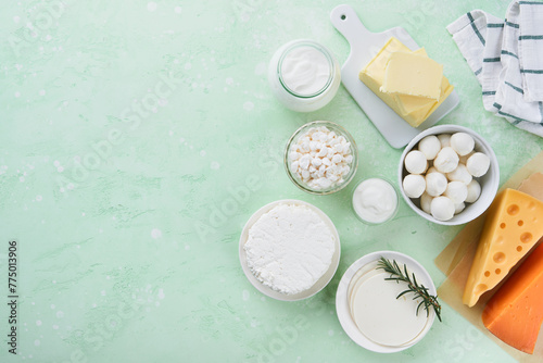 Dairy products or farm products. Fresh organic dairy products milk, cottage cheese, butter, cream, yogurt, sour cream and mozzarella on a light green slate, stone or concrete background. Top view.