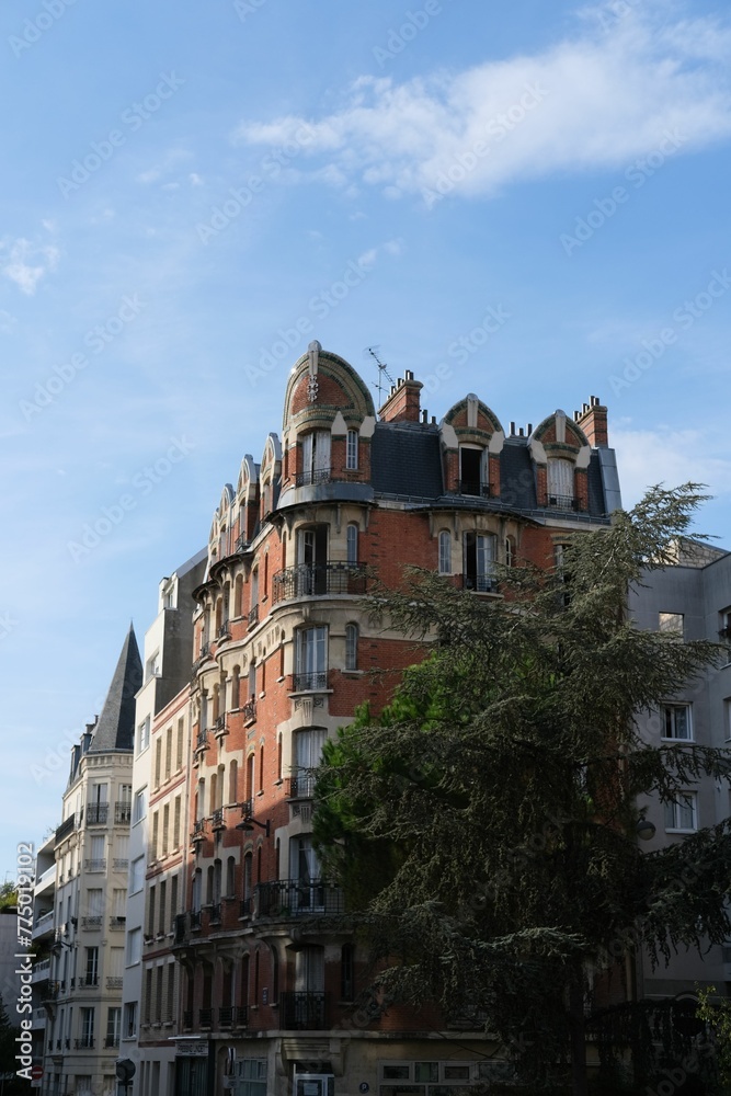 Naklejka premium Vertical shot of a historic building exterior with nearby ivy plants in Paris, France