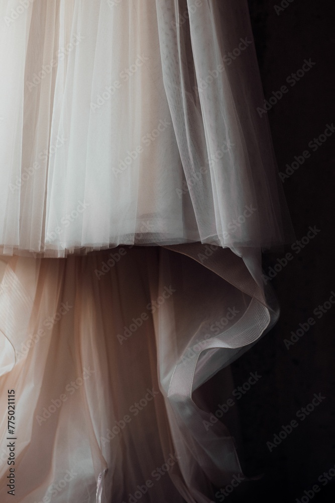 Vertical shot of a detail of a white chiffon wedding dress