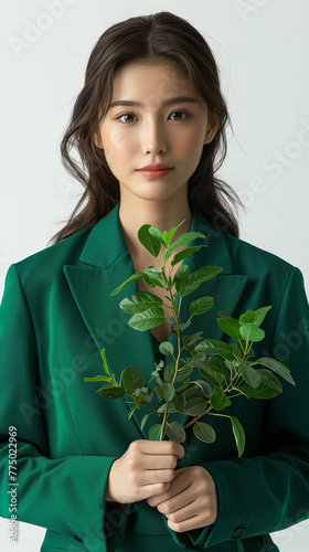 Consultant végétal, allégorie de la croissance verte et de la RSE en entreprise, manager en costume vert tenant une plante dans ses mains photo