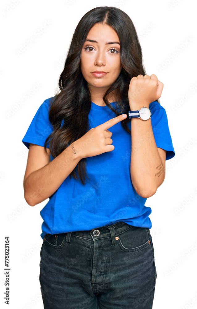 Beautiful brunette young woman wearing casual clothes in hurry pointing to watch time, impatience, looking at the camera with relaxed expression Beautiful brunette young woman wearing casual clothes in hurry pointing to watch time, impatience, looking at the camera with relaxed expression