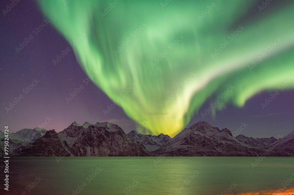 Scenic view of polar lights over the mountain next to the lake