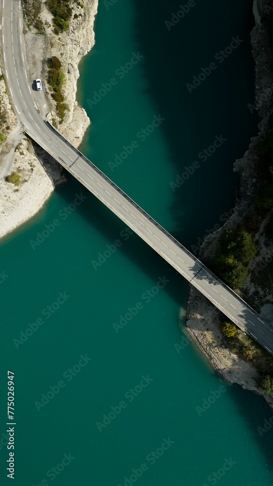 Aerial view of a bridge over a green clean lake on a sunny day