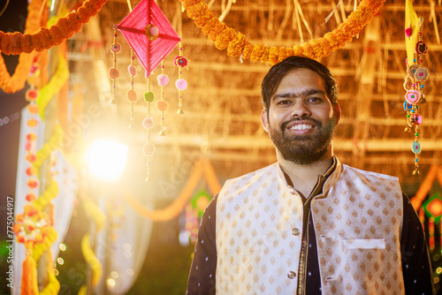 Indian man in traditional wear or kurta pyjama cloths. Male fashion model in sherwani, posing / standing against wedding mandap background photo
