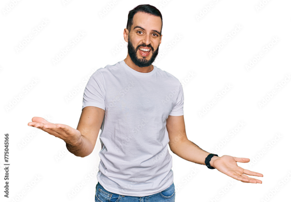 Young man with beard wearing casual white t shirt smiling cheerful with open arms as friendly welcome, positive and confident greetings Young man with beard wearing casual white t shirt smiling cheerful with open arms as friendly welcome, positive and confident greetings