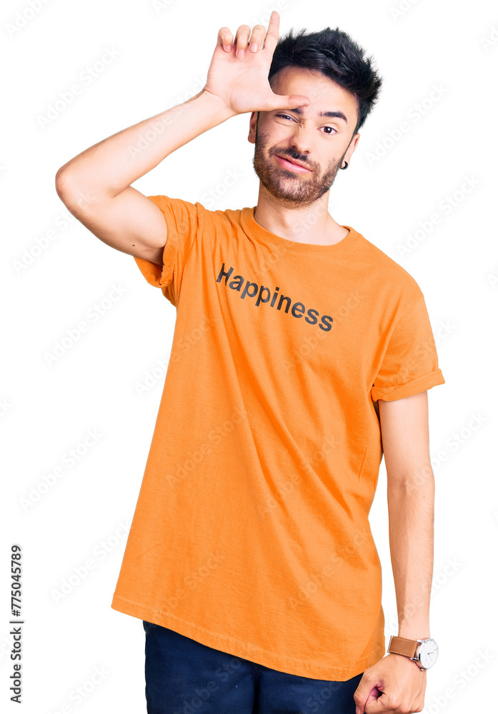 Young hispanic man wearing t shirt with happiness word message making fun of people with fingers on forehead doing loser gesture mocking and insulting. Young hispanic man wearing t shirt with happiness word message making fun of people with fingers on forehead doing loser gesture mocking and insulting.