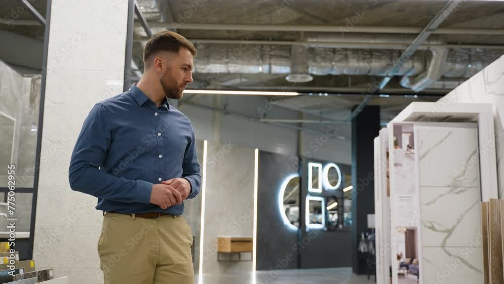 A man walking at shop and chooses tiles A man walking at shop and chooses tiles