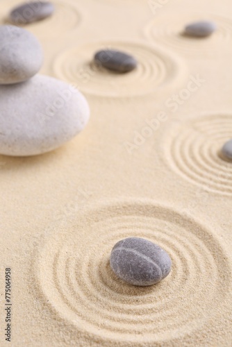 Zen garden stones on sand with pattern, closeup