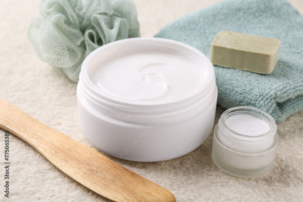 Body care cream in open jars on light textured table, closeup Body care cream in open jars on light textured table, closeup