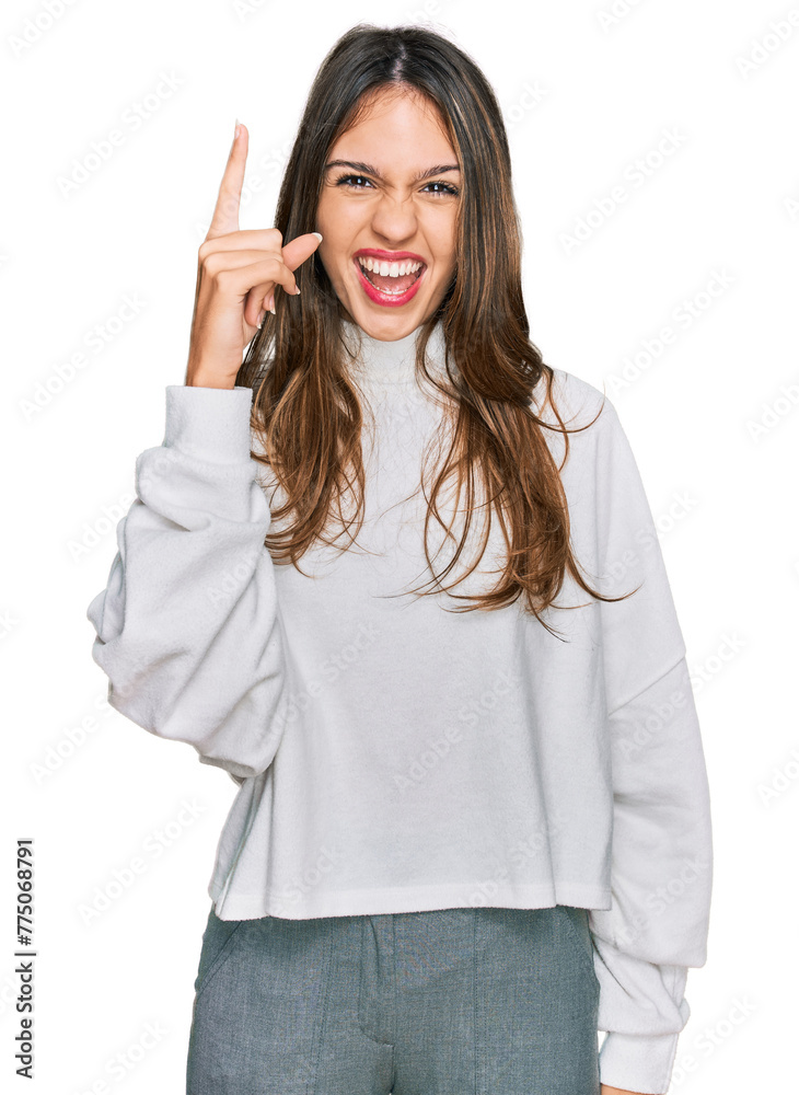 Young brunette woman wearing casual turtleneck sweater pointing finger up with successful idea. exited and happy. number one. Young brunette woman wearing casual turtleneck sweater pointing finger up with successful idea. exited and happy. number one.