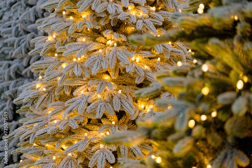 Artificial Christmas tree decorated with light bulbs and frost