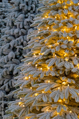 Artificial Christmas tree decorated with light bulbs and frost