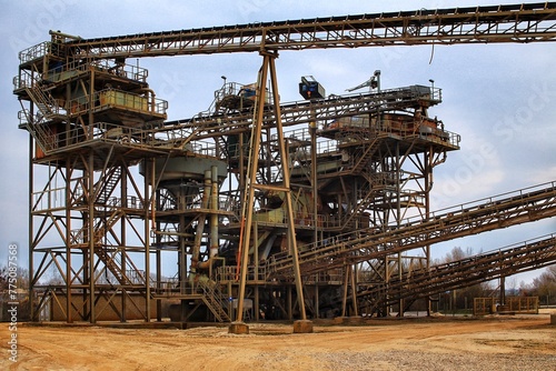 Grungy shot of gravel quarry, with rusty metal frames and and conveyor belts