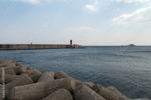 Seascape with the lighthouse on the seawall photo