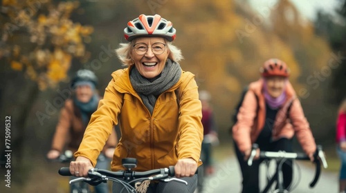 Outdoors in nature, two active senior women friends cycling together.
