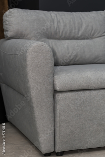 Gray soft sofa in the interior against a gray wall