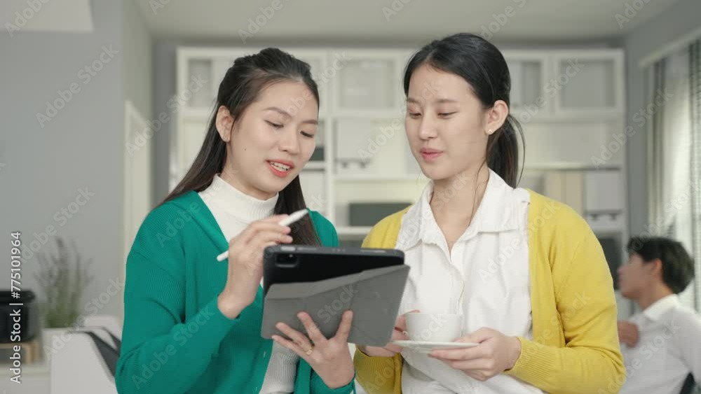 Working together on project. asian two young business colleagues working on laptop
