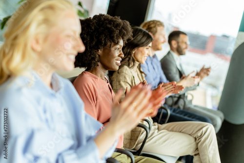 Energetic applause by a diverse group at a casual indoor event