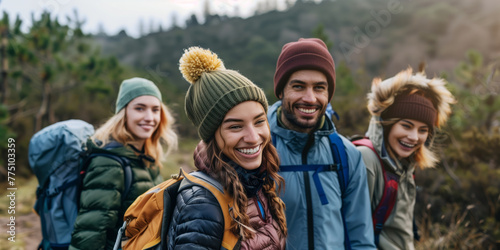 Group of cheerful young friends going hiking together in scenic landscape on spring day. Adventurous young people with backpacks. Hiking and trekking on a nature trail.