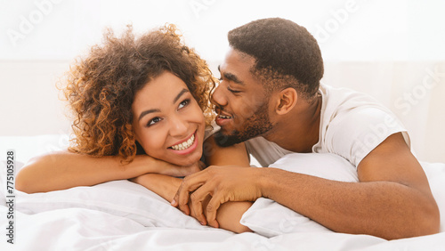 Beautiful lovers lying in bed at home