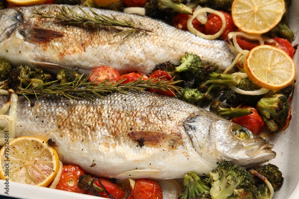 Delicious fish with vegetables and lemon in baking dish, closeup