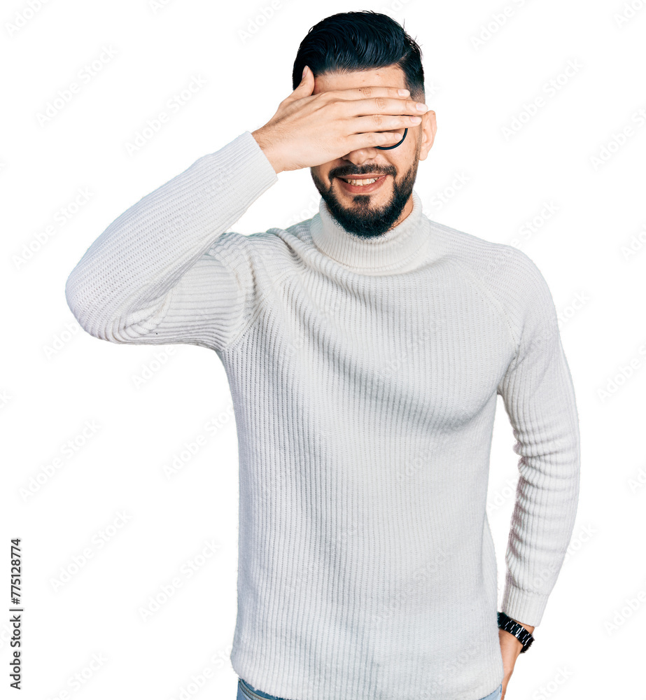 Young arab man with beard wearing elegant turtleneck sweater and glasses smiling and laughing with hand on face covering eyes for surprise. blind concept. Young arab man with beard wearing elegant turtleneck sweater and glasses smiling and laughing with hand on face covering eyes for surprise. blind concept.