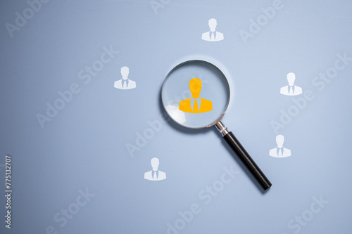 Human icon inside vintage magnifying glass for focus business objective on blue background and copy space, human development recruitment leadership and customer target group concept.