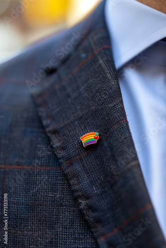 Close up enamel LGBTQ+ lapel pin on a business suit 