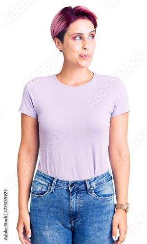 Young beautiful woman with pink hair wearing casual clothes smiling looking to the side and staring away thinking.